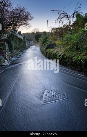 Regenwasser fließt die Trellech Straße hinunter in Tintern. Stockfoto