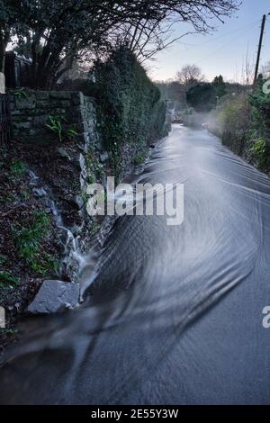 Regenwasser fließt die Trellech Straße hinunter in Tintern. Stockfoto