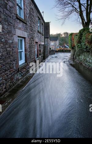 Regenwasser fließt die Trellech Straße hinunter in Tintern. Stockfoto
