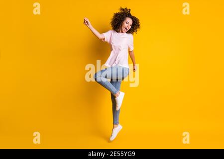 Foto-Portrait Ganzkörperansicht des Mädchens springen auf einem Bein schreien isoliert auf lebendige gelb farbigen Hintergrund. Stockfoto