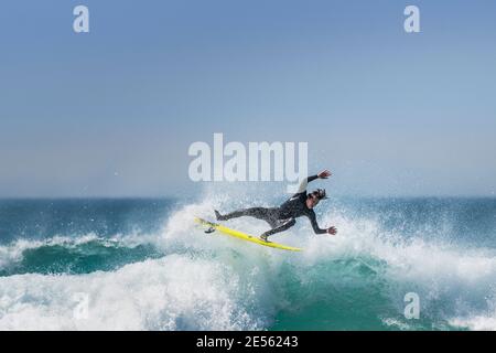 Spektakuläre Action, während ein Surfer eine Welle in Fistral in Newquay in Cornwall reitet. Stockfoto