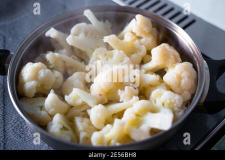 Blumenkohlblüten Blütenstände werden in einer Pfanne gekocht, leckere gesunde Gemüsekost, Kochen Abendessen, Stockfoto