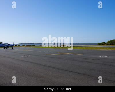 Landebahn am Rande der Insel mit Hintergrundwasser und Kleinflugzeug, George T. Lewis Airport, Cedar, Key, Florida, USA. Stockfoto