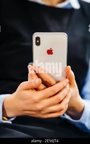 Paris, Frankreich - Oct 2, 2018: Close-up Business Frau Hodling neuen Apple Computers iPhone Smartphone normal - Fokus auf Hände mit Logo der Rückseite des Glastelefons Stockfoto