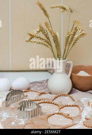 Ausschneiden von herzförmigen Plätzchen aus rohem Teig mit Ausstechformen. Stockfoto