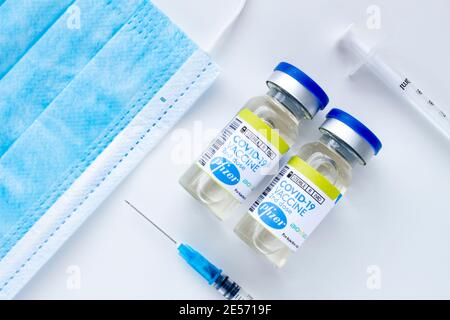 Calgary, Alberta. Kanada. Januar 25 2021. Ein paar Pfizer Covid-19 Impfstoffflaschen mit sterilen Spritzen und einer Gesichtsmaske Stockfoto