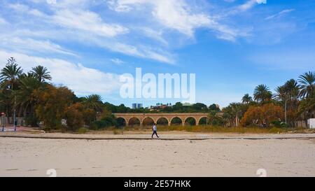 Alicante, Spanien - Januar 2021: Blick auf die alte Steinbrücke am Strand von Campoamor, Orihuela Costa Stockfoto