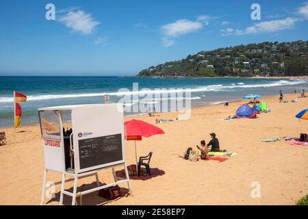 Palm Beach in Sydney und Strandgänger genießen einen faulen Sommertag am Strand, bewacht von australischem Rettungsschwimmer, Sydney Stockfoto