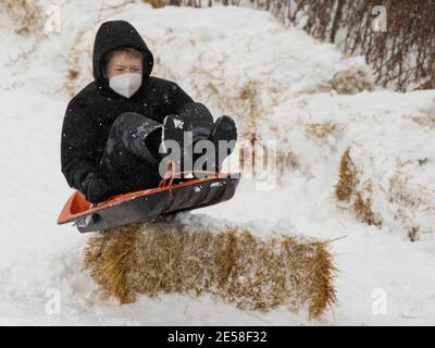 Chicago, USA. Januar 2021. Ein Junge hat Spaß mit seinem Schlitten auf einem Hügel in der Nähe von Burnham Harbour in Chicago, Illinois, USA, am 26. Januar 2021. Ab Montagabend kam es in Chicago zu einem Wintersturm. Bis 9 Uhr Ortszeit Dienstag, waren die Schneesummen in einigen Teilen der Chicago-Gegend nahe an 8 Zoll gekommen. Quelle: Joel Lerner/Xinhua/Alamy Live News Stockfoto