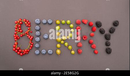 Die Inschrift BERRY besteht aus reifen, saftigen, süßen Beeren auf schwarzem Grund. Verschiedene mehrfarbige Beeren in Form von Buchstaben ausgelegt. lett Stockfoto