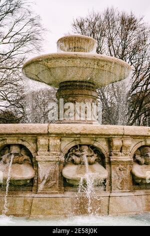 Ein großer Straßenbrunnen, gefüllt mit Wasser mit Mustern aus Stein, in München, Deutschland. Stockfoto