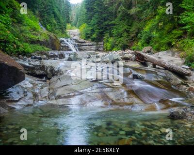 Der Denny Creek Trail ist sehr beliebt und aus gutem Grund! Eine natürliche Wasserrutsche, zwei recht große Wasserfälle, viele alte Wälder gemischt in w Stockfoto