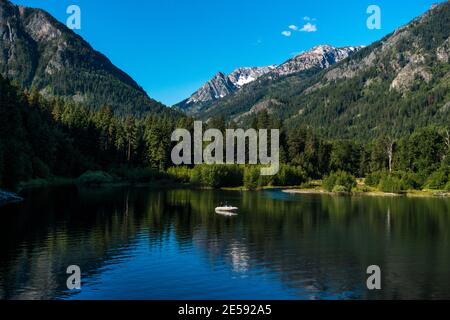 Menschen, die am südlichen Ende des Wallowa Lake angeln, mit den Gipfeln innerhalb der Eagle Cap Wilderness Area im Hintergrund. Stockfoto