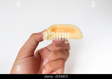 Bakpia Kukus Kuchen oder gedämpfte Bakpia Kuchen mit Käse Geschmack auf der Hand isoliert auf weißem Hintergrund. Indonesien-china traditionelle Torte aus yogyakarta Stockfoto