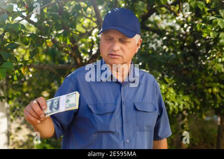 Ein älterer Mann, der einen Stapel Geld hält Stockfoto