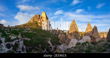 Panorama burg uchisar und die Stadt sind Sandsteinberge mit Tunneln und Fenstern gefüllt. Am Morgen trifft die Sonne auf die goldenen Gipfel und blaue s Stockfoto