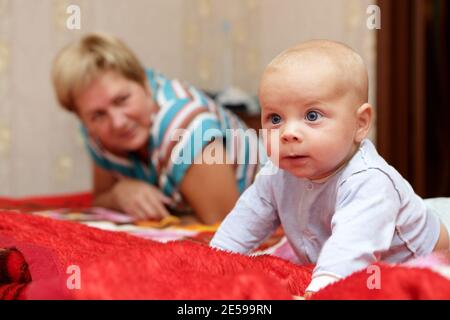 Denkendes Baby mit seiner Großmutter auf einem Bett Stockfoto