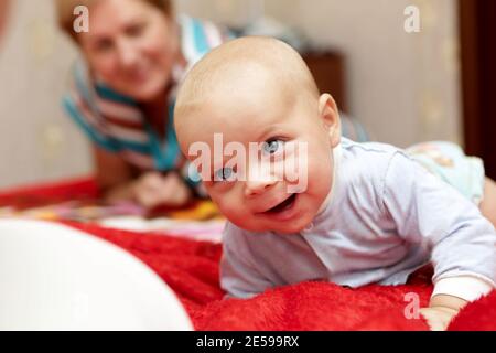 Glückliches Baby mit seiner Großmutter auf einem Bett Stockfoto