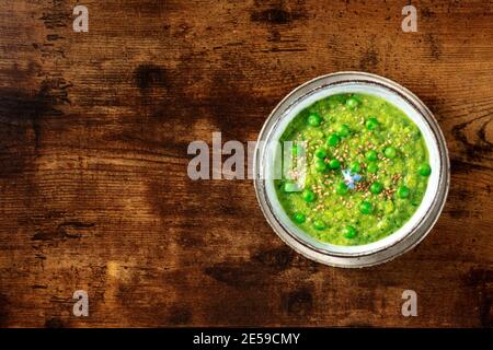 Vegane grüne Suppe, über Kopf geschossen auf einem dunklen rustikalen Holzhintergrund mit Copyspace Stockfoto