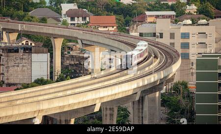 Der elektrische Skytrain fährt durch die Stadt, Gebäude und Häuser. Stockfoto