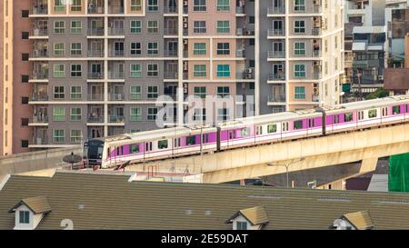 Der elektrische Skytrain fährt durch die Stadt, Gebäude und Häuser. Stockfoto
