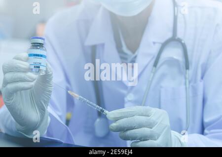 Männlicher Arzt mit einer Flasche COVID-19-Impfstoff oder Der Coronavirus-Impfstoff und die Spritze Stockfoto