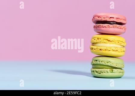 Macaron. Traditionelle französische bunte Makronen Nahaufnahme, Makro auf blauem und rosa Hintergrund Stockfoto