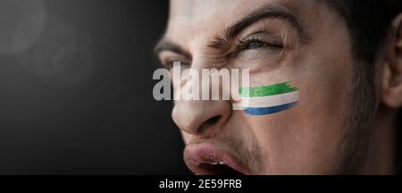 Ein schreiender Mann mit dem Bild von Sierra Leone Nationalflagge auf seinem Gesicht Stockfoto