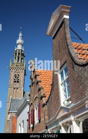 Bunte Fassaden historischer Häuser in Edam, Nordholland, Niederlande, mit dem Speeltoren (Glockenspielturm) im Hintergrund Stockfoto