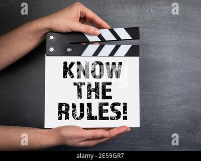 KENNEN SIE DIE REGELN. Geschäftshintergrund. Film Klapper in Frau Hand. Schwarzer Kreidetafel Hintergrund. Stockfoto