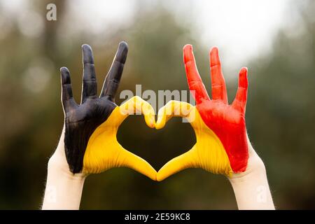 Kinder Hände in Belgien Flagge Farbe gemalt zeigen Symbol von Herz und Liebe Geste auf Natur Hintergrund Stockfoto