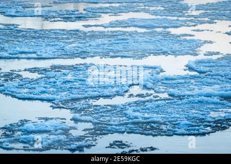Schmelzendes Eis, das auf der Wasseroberfläche fließt. Eisdrift auf dem Fluss. Globale Erwärmung. Stockfoto