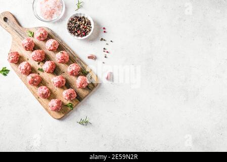 Rohe Fleischbällchen auf weißem Hintergrund, Draufsicht, Kopierraum. Fleischbällchen für Rindfleisch bereit zum Kochen. Stockfoto