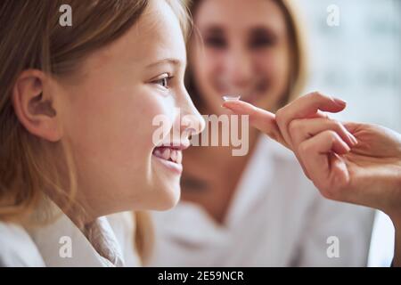 Junge Teenager Mädchen Auswahl und versuchen Linsen in Augenheilkunde Klinik Stockfoto