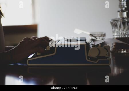 Vintage-Foto von alten Büchern. Die Hand des Schriftstellers ist auf der Schreibmaschine .Writer Schreiben eines Liebesromans. Romancier schreibt Roman auf einer Schreibmaschine Stockfoto