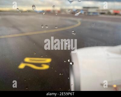 Rolling am Flughafen an einem schlechten Wetter regnerischen Tag. Blick aus Flugzeugfenster auf Rollbahn Asphalt.Raindrops auf Fenster. Hochwertige Fotos Stockfoto