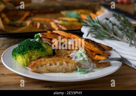 Fisch mit Süßkartoffeln und Brokkoli mit Sauce Stockfoto