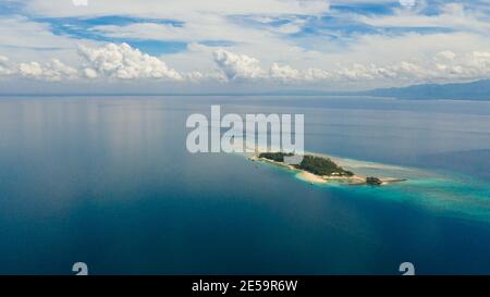Blick von oben auf die kleine tropische kleine Insel Liguid im blauen Meer mit einem Korallenriff und dem Strand. Little Cruz Island, Philippinen, Samal. Stockfoto