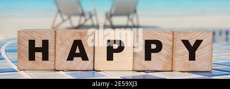 Happy Word Holzwürfel auf einem Ozean Hintergrund. Lifestyle-Konzept Stockfoto