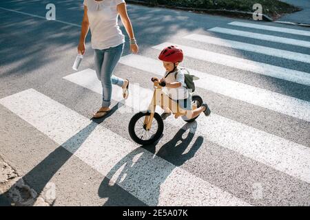 Kleiner Junge auf Fahrrad Kreuzung Straße an Zebra Kreuzung. Stockfoto