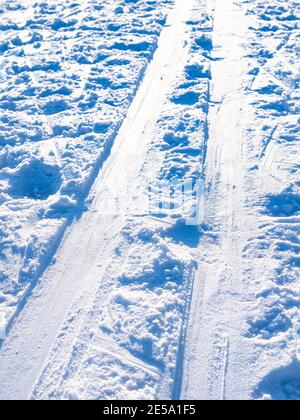 Die Skipiste wird von der Sonne aus nächster Nähe auf schneebedeckten gefrorenen Pisten beleuchtet Oberfläche des Flusses auf kalt in kalten sonnigen Wintertag Stockfoto