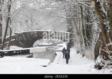Die schneebedeckte Szene entlang des Coventry Kanals in der Nähe von Atherstone, North Warwickshire. Im Bild sind Wanderer entlang des Kanals in der Nähe des Zentrums von Atherstone Town. Stockfoto
