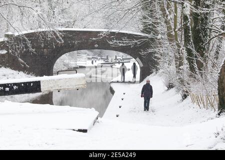 Die schneebedeckte Szene entlang des Coventry Kanals in der Nähe von Atherstone, North Warwickshire. Im Bild sind Wanderer entlang des Kanals in der Nähe des Zentrums von Atherstone Town. Stockfoto