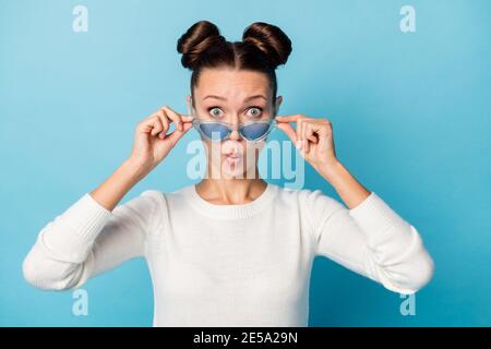 Foto von geschockt Dame nehmen Brille überrascht Gesicht tragen weißen Pullover isoliert blauen Hintergrund. Stockfoto