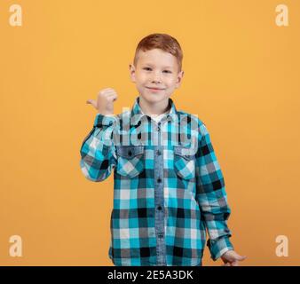 Fröhliche Ingwer-Kind in Flanell zeigt auf Kopierer Raum Stockfoto