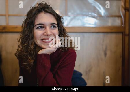 Flacher Fokus einer lockigen Frau lächelnd Stockfoto