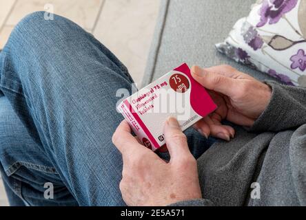 Nahaufnahme des Mannes Person hält Box von Clopidogrel Blutverdünner Medizin Pillen Tabletten Healthcare Drug Drug Drug Medicine Stockfoto