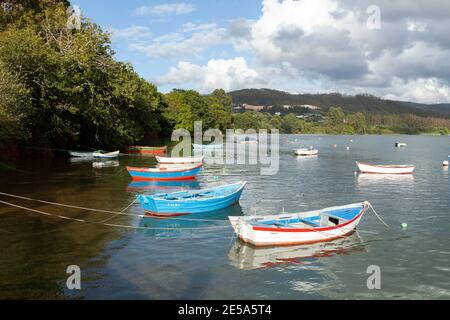 Fischerboote vertäuten in einer ruhigen Meereslandschaft in der Nähe des Dorfes Ladrido, in der Mündung von Ortigueira, im Norden Galiciens, Spanien. Stockfoto