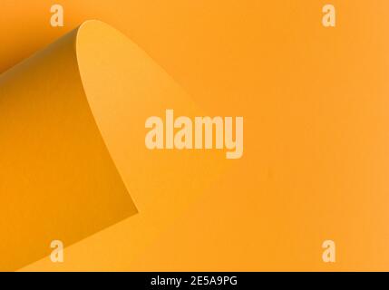Orange abstraktes Farbpapier für Hintergrund, monochrom gewellte Ecke, Seite gewellt. Abstrakter kreativer Hintergrund, modernes Modell. Designelement für Adve Stockfoto
