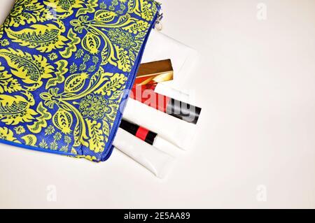 Nahaufnahme eines offenen Reise-Etui (Beutel) voller Kosmetik (Lippenstift, Handcreme, Gesichtscreme) Stockfoto